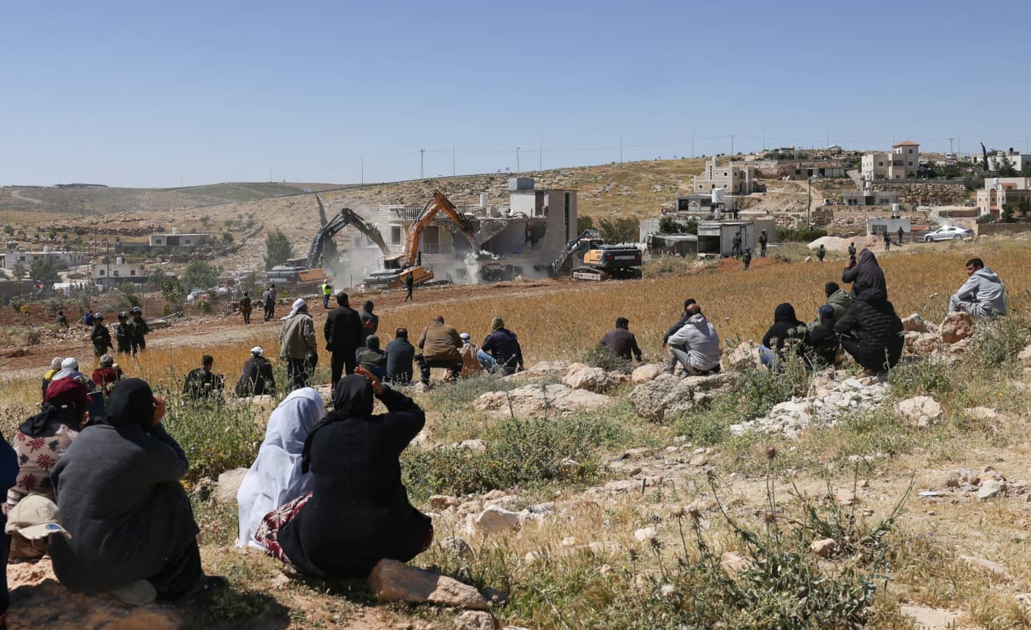 Palestinos observan cómo demuelen una casa palestina