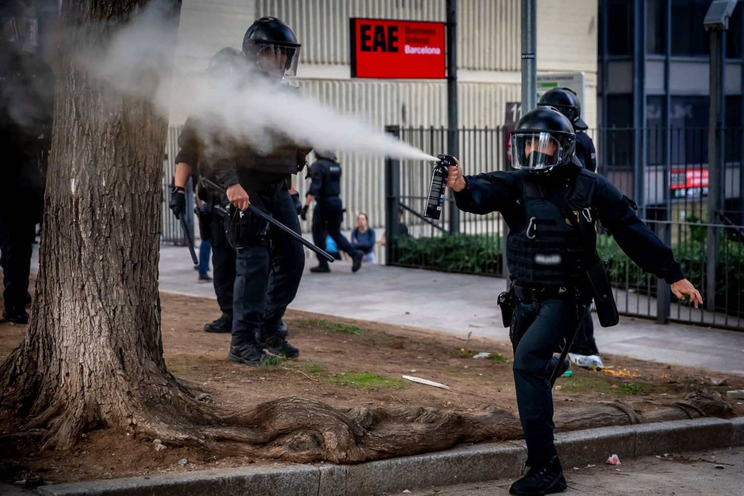 Un policia dispara gas pimienta en una manifestación